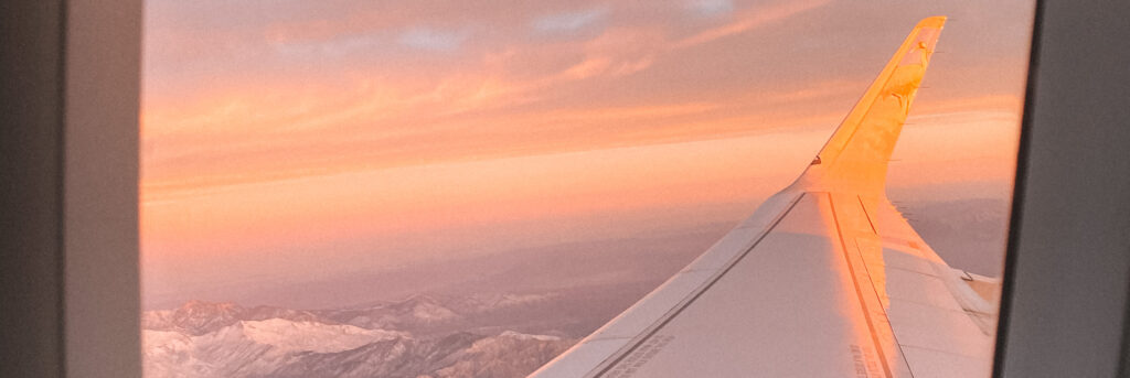 View of an airplane wing from the window during sunset